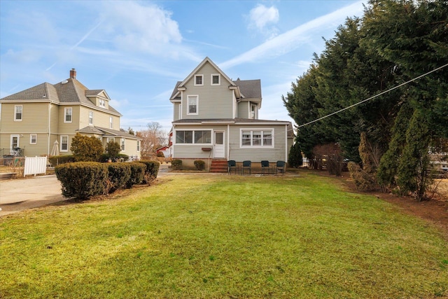 back of house with a lawn