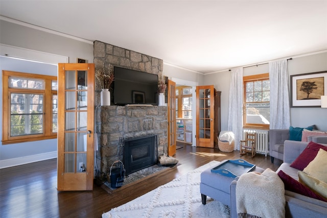 living room featuring wood finished floors, french doors, radiator, a fireplace, and crown molding