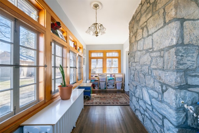 interior space featuring plenty of natural light, a chandelier, and dark wood-style flooring