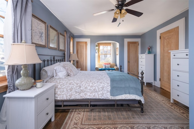 bedroom featuring arched walkways, ceiling fan, and wood finished floors