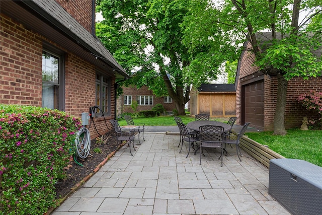 view of patio with outdoor dining area and a garage