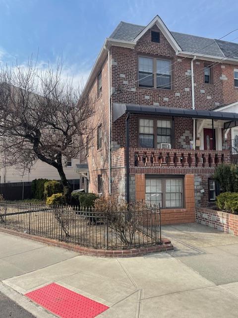 view of front of property with a fenced front yard and brick siding