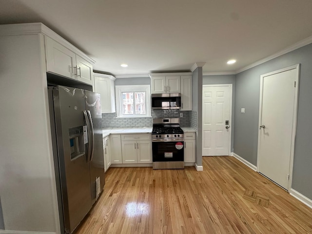 kitchen featuring white cabinets, tasteful backsplash, ornamental molding, and stainless steel appliances