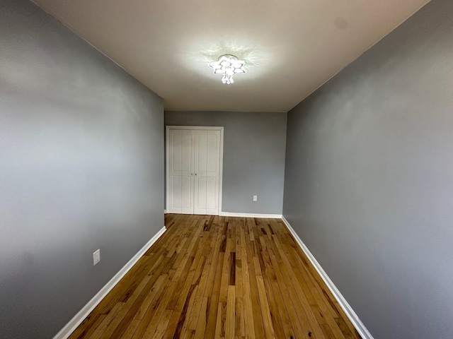 hallway with hardwood / wood-style floors and baseboards