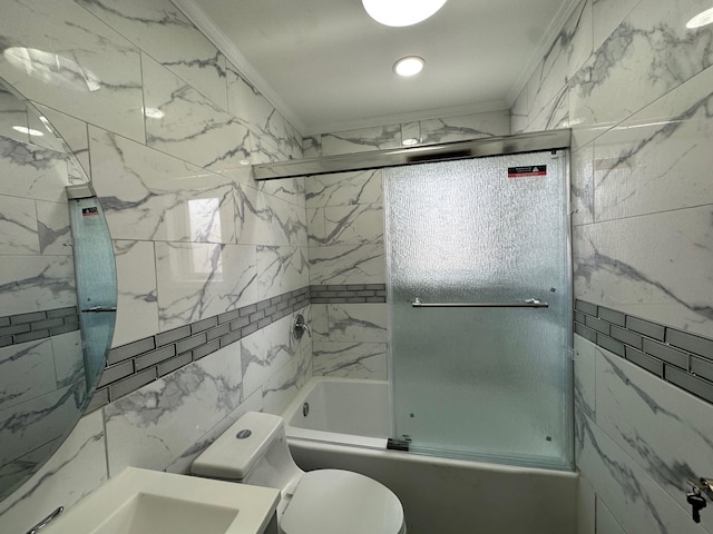 bathroom featuring a sink, crown molding, toilet, and bath / shower combo with glass door