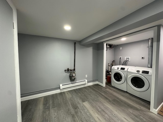 laundry room featuring a baseboard radiator, wood finished floors, separate washer and dryer, laundry area, and baseboards