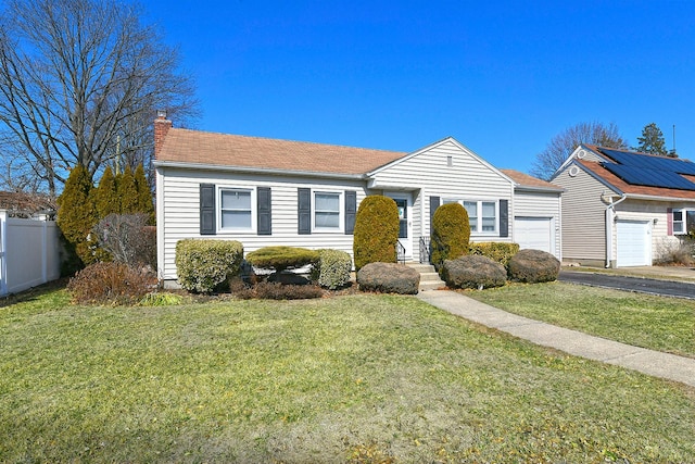 view of front of home featuring a front lawn, fence, an attached garage, and aphalt driveway