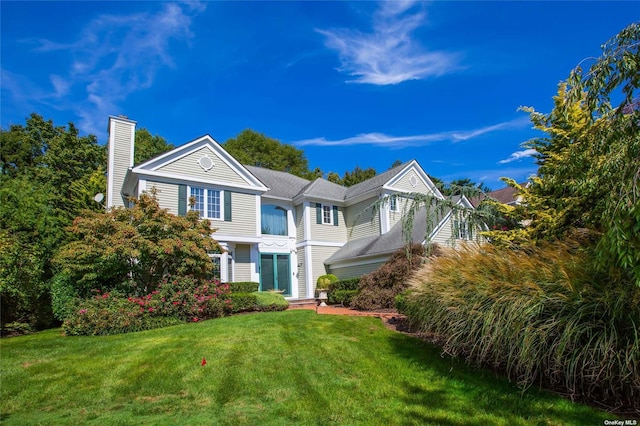 view of front of house with a chimney and a front lawn