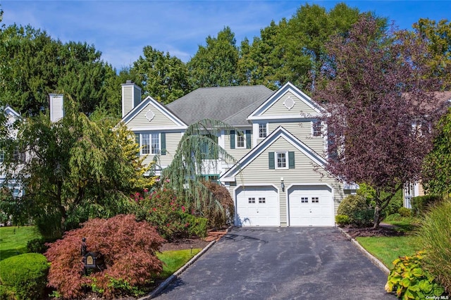 view of front of home featuring driveway and a chimney