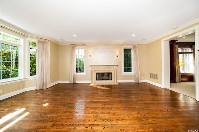 unfurnished living room featuring a fireplace with flush hearth, visible vents, wood finished floors, and ornamental molding