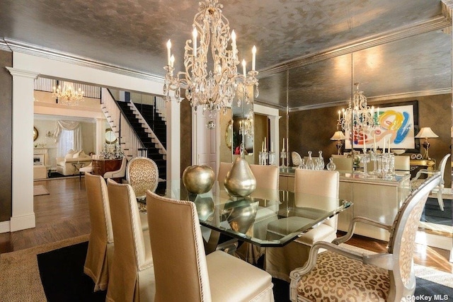 dining room with ornamental molding, wood finished floors, stairway, and an inviting chandelier