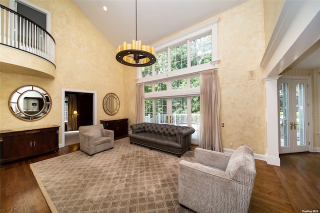 living room with a notable chandelier, baseboards, dark wood-style flooring, and french doors