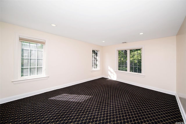 carpeted spare room featuring a healthy amount of sunlight, recessed lighting, and baseboards