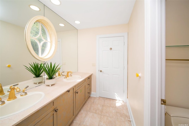 full bathroom with baseboards, double vanity, a sink, and recessed lighting