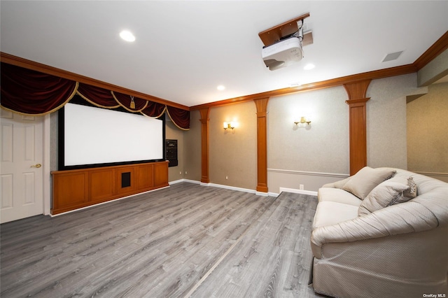 home theater featuring light wood-style flooring, baseboards, crown molding, and recessed lighting