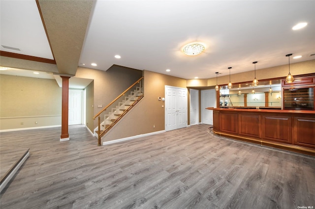 kitchen featuring baseboards, open floor plan, wood finished floors, and recessed lighting