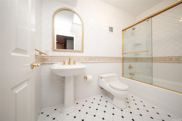 bathroom with toilet, visible vents, tile walls, and enclosed tub / shower combo