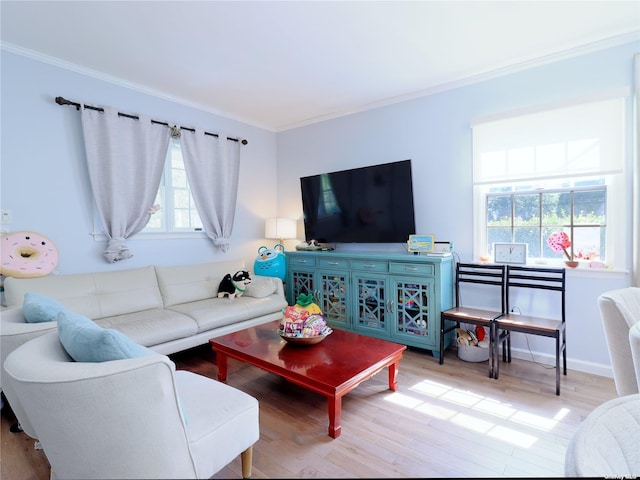 living area with ornamental molding, a healthy amount of sunlight, and wood finished floors