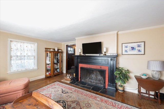 living area with baseboards, a fireplace, wood finished floors, and crown molding