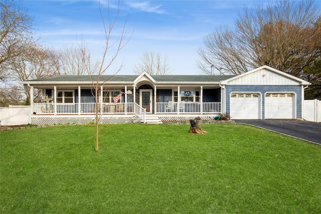 ranch-style house featuring a porch, a garage, driveway, and a front lawn