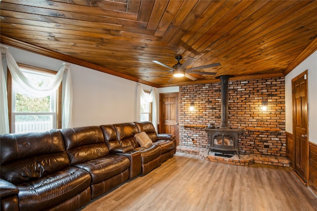 living room featuring a wood stove, wood ceiling, and crown molding