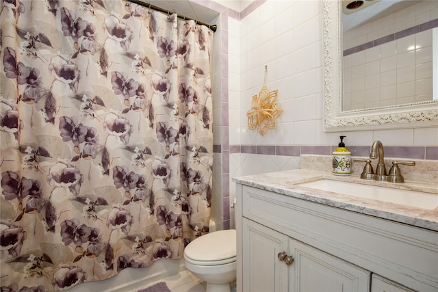 bathroom featuring shower / tub combo, tile walls, toilet, and vanity