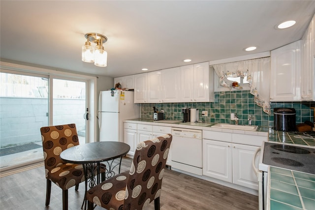 kitchen with light wood finished floors, white appliances, tile counters, and white cabinetry