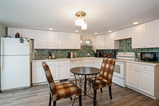 kitchen with tile counters, white appliances, white cabinetry, and decorative backsplash