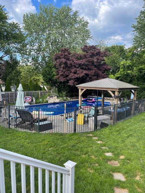 community pool featuring fence and a yard