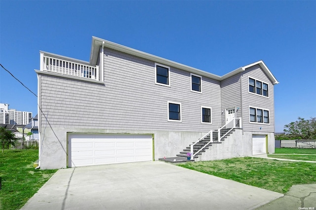 view of front facade with a garage, driveway, a front lawn, and stairs