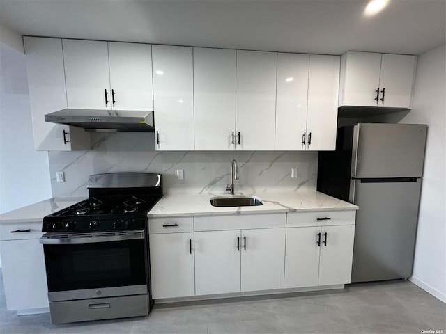 kitchen with white cabinets, appliances with stainless steel finishes, under cabinet range hood, and a sink