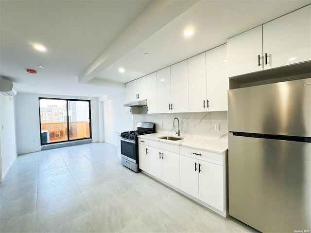 kitchen with a sink, under cabinet range hood, tasteful backsplash, appliances with stainless steel finishes, and white cabinets