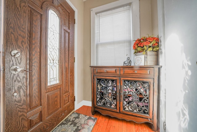 foyer entrance featuring baseboards and wood finished floors