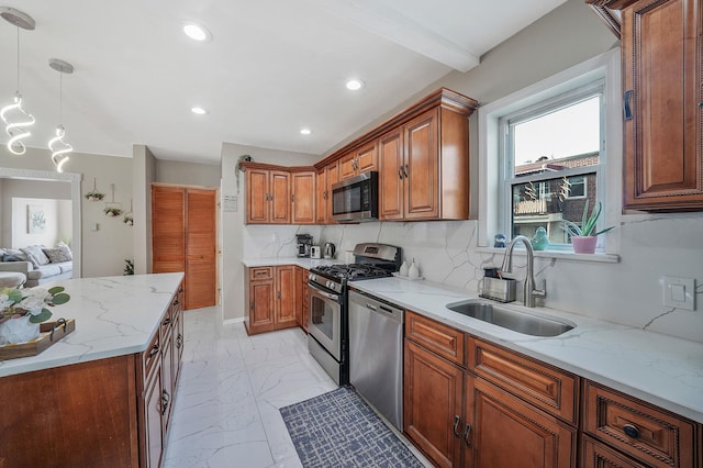 kitchen with light stone counters, appliances with stainless steel finishes, brown cabinets, marble finish floor, and a sink