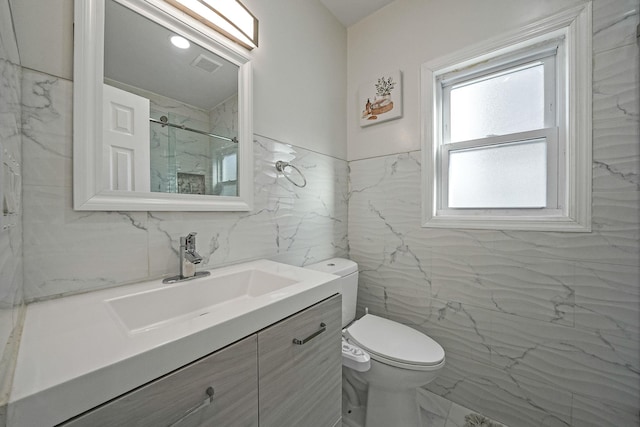 bathroom featuring a marble finish shower, visible vents, toilet, marble finish floor, and vanity