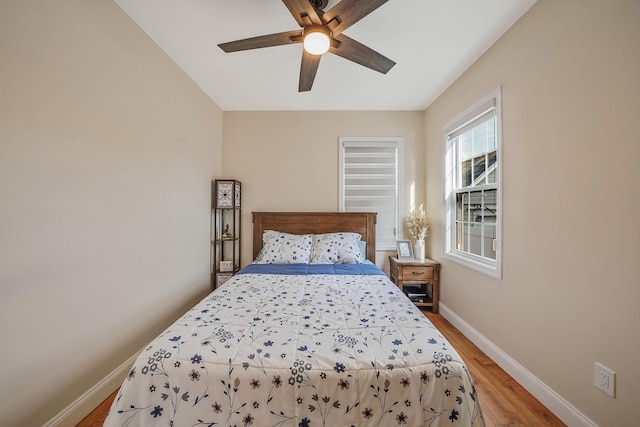 bedroom featuring light wood finished floors, ceiling fan, and baseboards