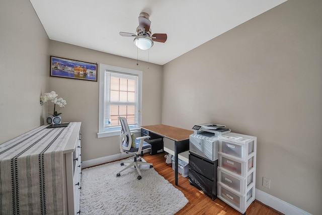 home office featuring a ceiling fan, baseboards, and wood finished floors