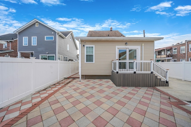 back of property featuring a deck, a patio area, and a fenced backyard