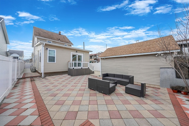 back of property with a shingled roof, a patio area, a fenced backyard, and an outdoor hangout area