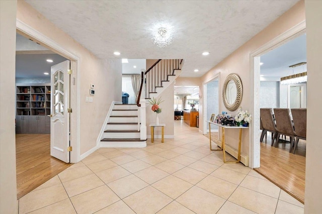 entryway featuring recessed lighting, stairs, baseboards, and tile patterned floors