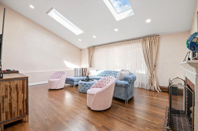 living room featuring vaulted ceiling with skylight, a fireplace, a wealth of natural light, and wood finished floors