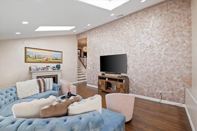 living room with stairs, vaulted ceiling with skylight, wood finished floors, and recessed lighting