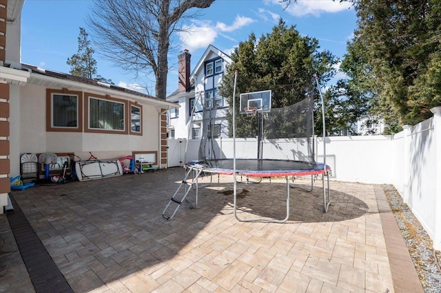 view of patio with a fenced backyard and a trampoline