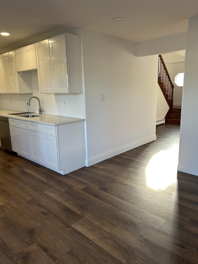 kitchen with dishwasher, dark wood-style floors, light countertops, and a sink