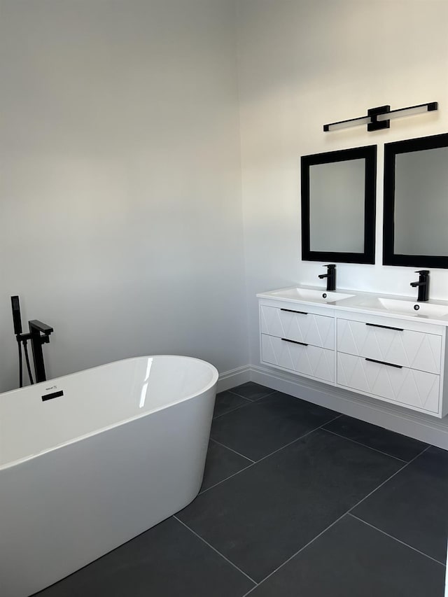 bathroom featuring double vanity, a freestanding tub, a sink, and tile patterned floors