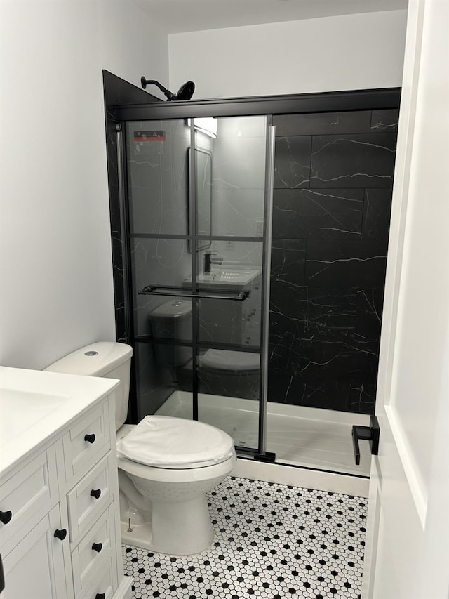 full bathroom featuring vanity, a shower stall, toilet, and tile patterned floors