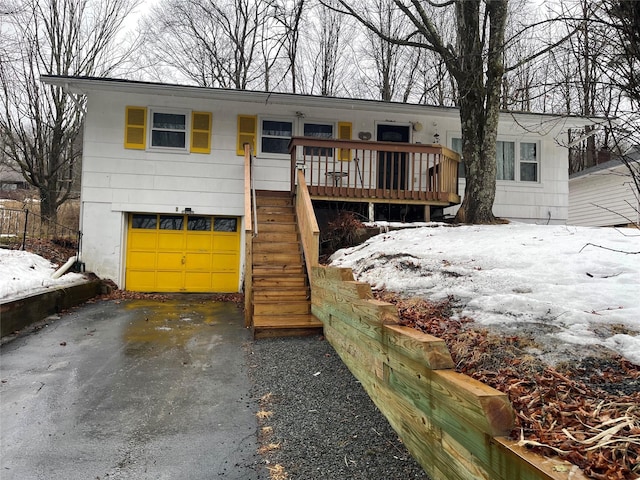 view of front facade with driveway, a garage, and stairway