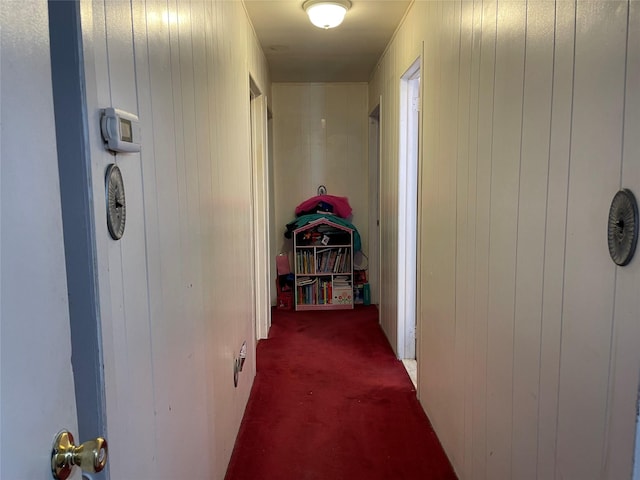 corridor with carpet flooring and wood walls