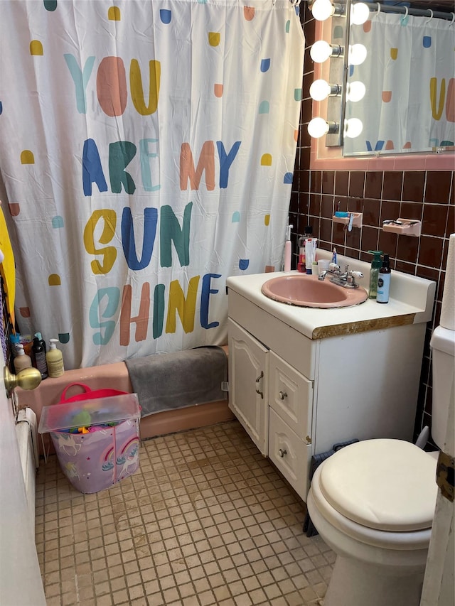 bathroom with tile walls, tasteful backsplash, toilet, shower / tub combo, and vanity