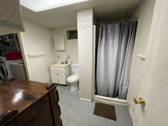 bathroom featuring toilet, vanity, a paneled ceiling, a shower stall, and separate washer and dryer